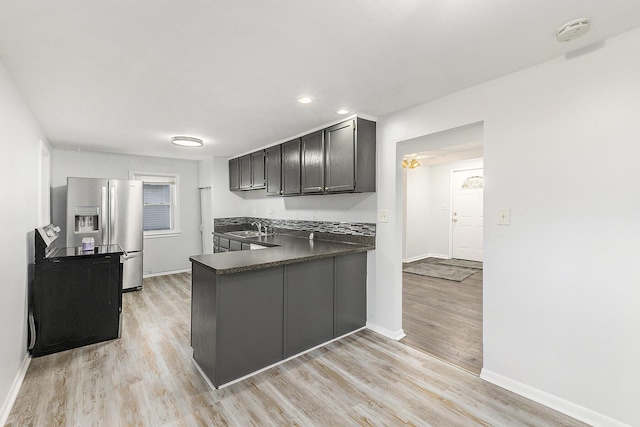 25949 Southwestern Hwy, Redford, MI 48239 - kitchen featuring stainless steel fridge, a sink, dark countertops, baseboards, and light wood-type flooring