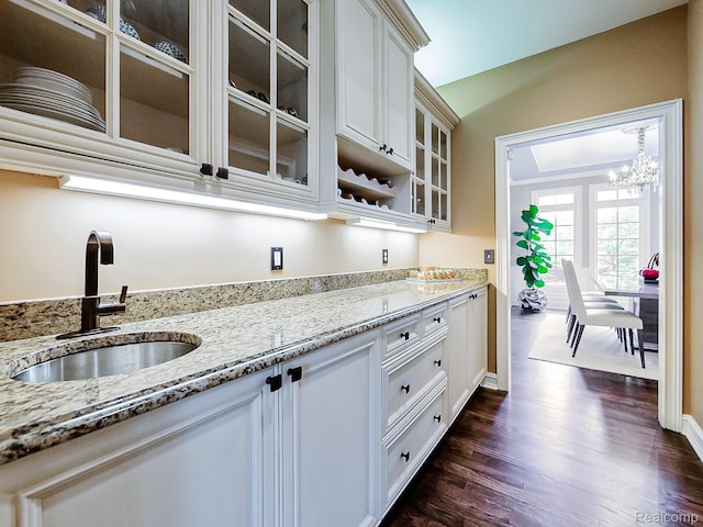 4575 Forest Edge Ln, West Bloomfield, MI 48323 - kitchen with a sink, light stone countertops, dark wood-type flooring, glass insert cabinets, and a chandelier