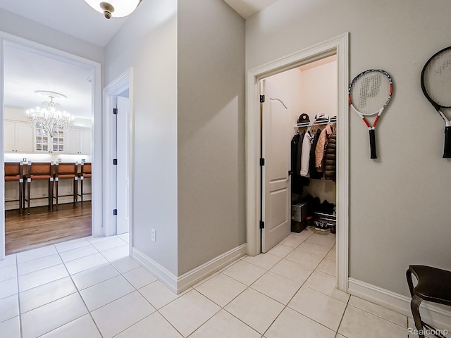 4575 Forest Edge Ln, West Bloomfield, MI 48323 - hall with a chandelier, light tile patterned floors, and baseboards