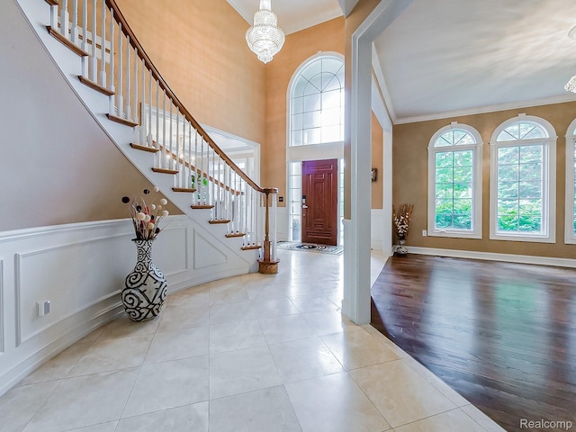 4575 Forest Edge Ln, West Bloomfield, MI 48323 - entrance foyer with a chandelier, crown molding, stairway, tile patterned flooring, and wainscoting
