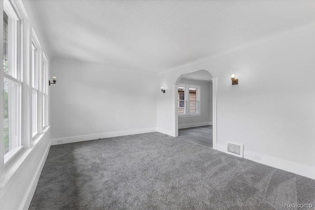 12242 Washburn St, Detroit, MI 48204 - carpeted spare room with arched walkways, a textured ceiling, and baseboards
