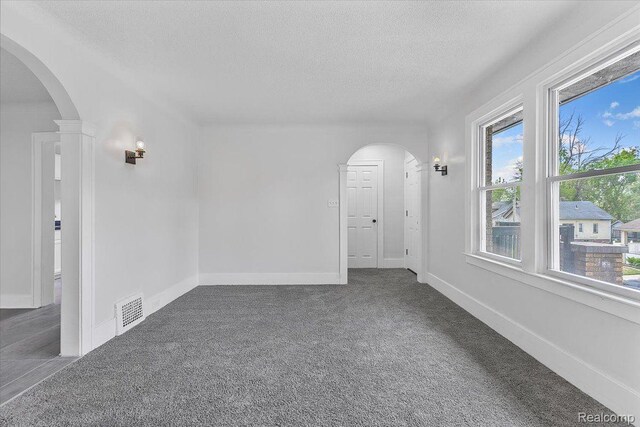 12242 Washburn St, Detroit, MI 48204 - carpeted empty room featuring a textured ceiling, arched walkways, and baseboards