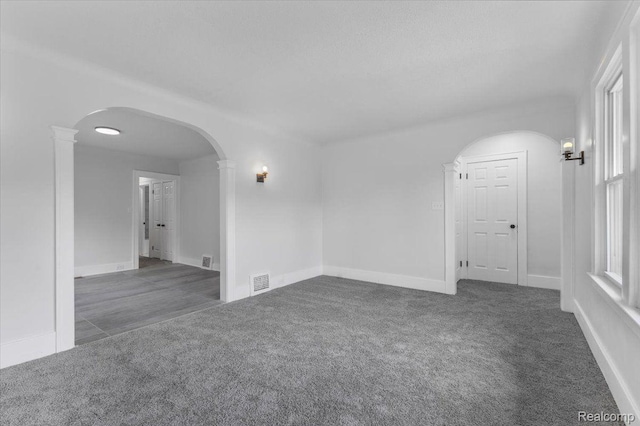 12242 Washburn St, Detroit, MI 48204 - empty room with carpet, arched walkways, and baseboards