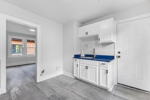 12242 Washburn St, Detroit, MI 48204 - kitchen featuring a sink, white cabinets, baseboards, and dark countertops