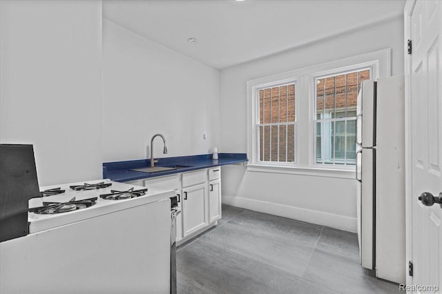12242 Washburn St, Detroit, MI 48204 - kitchen with white appliances, white cabinets, a sink, dark countertops, and baseboards
