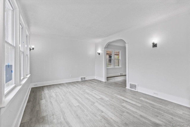 12242 Washburn St, Detroit, MI 48204 - unfurnished room featuring arched walkways, wood finished floors, and baseboards