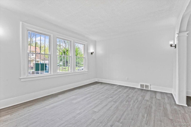 12242 Washburn St, Detroit, MI 48204 - spare room featuring a textured ceiling, wood finished floors, baseboards, and arched walkways