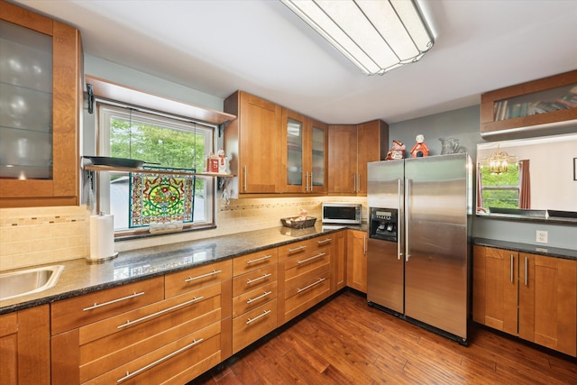 6544 Woodland Rd, Whitmore Lake, MI 48189 - kitchen featuring stainless steel appliances, brown cabinetry, dark wood-style flooring, and backsplash