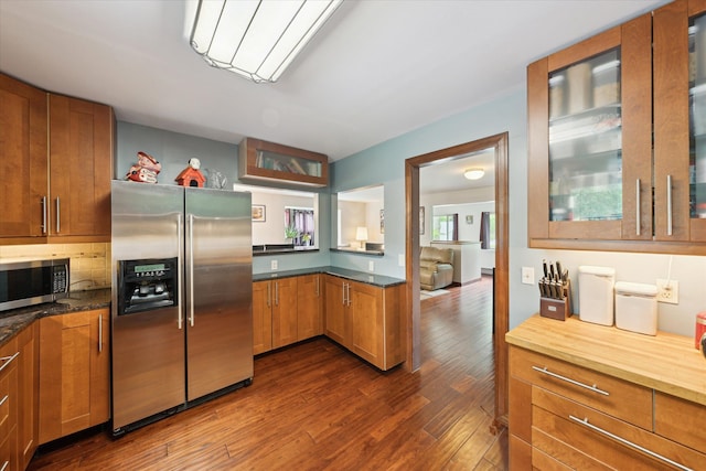 6544 Woodland Rd, Whitmore Lake, MI 48189 - kitchen with appliances with stainless steel finishes, dark wood-style floors, glass insert cabinets, and brown cabinetry