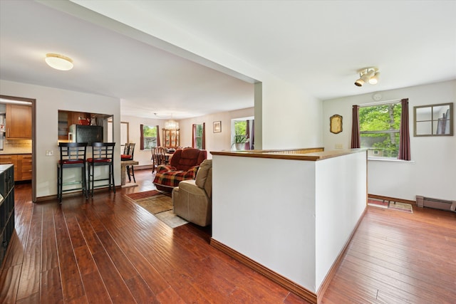 6544 Woodland Rd, Whitmore Lake, MI 48189 - living room featuring dark wood-style flooring, baseboards, and a baseboard heating unit