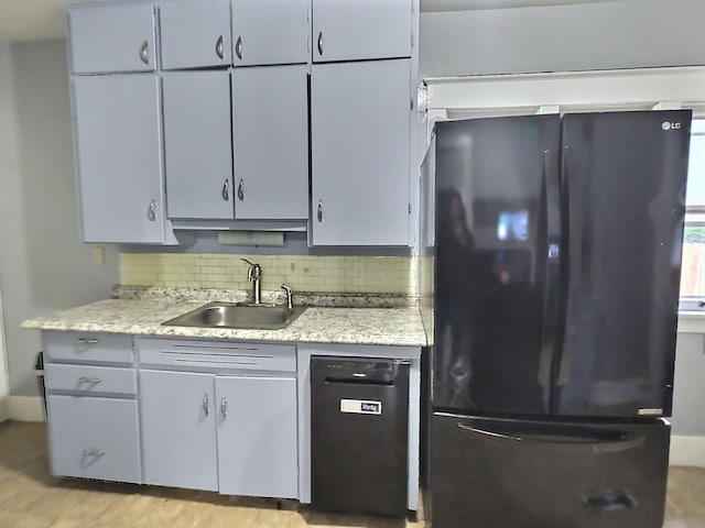 5014 Ford St, Swartz Creek, MI 48473 - kitchen featuring freestanding refrigerator, a sink, decorative backsplash, and light stone counters