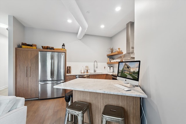 804 N Main St Unit 2C, Rochester, MI 48307 - kitchen with appliances with stainless steel finishes, a sink, light wood-style flooring, a peninsula, and a breakfast bar area