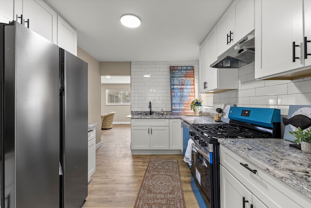 8903 Appleton, Redford, MI 48239 - kitchen featuring freestanding refrigerator, stainless steel gas range oven, under cabinet range hood, light wood-type flooring, and white cabinets