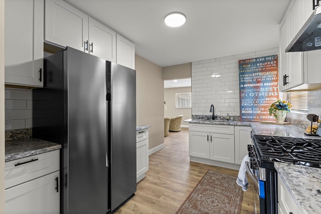 8903 Appleton, Redford, MI 48239 - kitchen with stainless steel appliances, under cabinet range hood, backsplash, and light wood-style floors