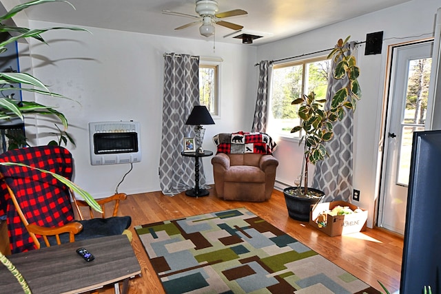 2741 E M 72, Grayling, MI 49738 - living area with heating unit, ceiling fan, wood finished floors, and a baseboard radiator