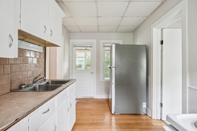 533 W Ganson St, Jackson, MI 49201 - kitchen with freestanding refrigerator, a drop ceiling, a sink, decorative backsplash, and light wood-style floors