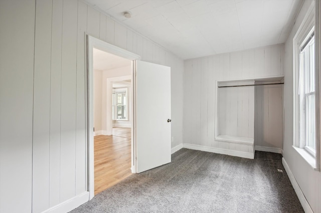 533 W Ganson St, Jackson, MI 49201 - unfurnished bedroom with carpet, multiple windows, and wooden walls