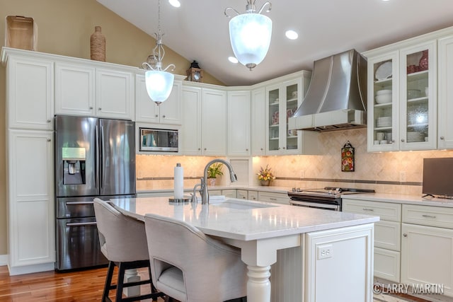7708 Stations Dr SW, Byron Center, MI 49315 - kitchen featuring stainless steel appliances, wall chimney range hood, a sink, light wood finished floors, and white cabinets