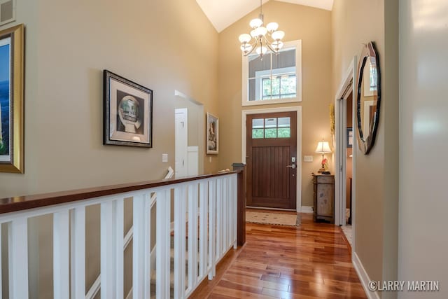 7708 Stations Dr SW, Byron Center, MI 49315 - entrance foyer with wood-type flooring, a chandelier, high vaulted ceiling, and baseboards