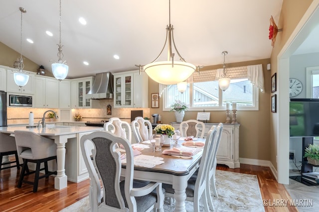 7708 Stations Dr SW, Byron Center, MI 49315 - dining area with light wood finished floors, recessed lighting, baseboards, and lofted ceiling