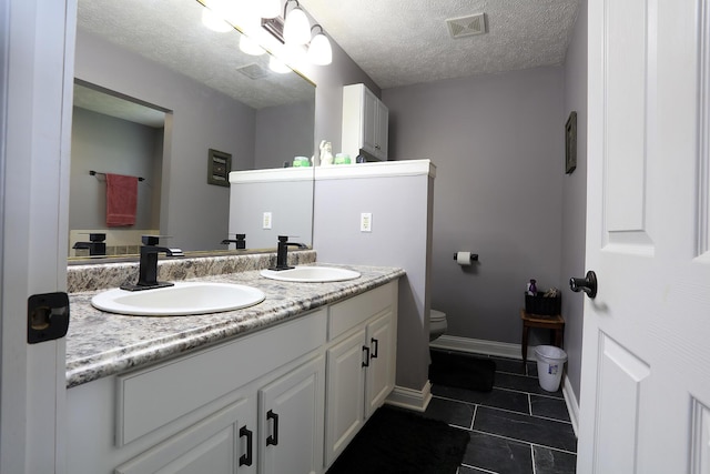 113 Davis Dr, Brooklyn, MI 49230 - bathroom with toilet, tile patterned floors, double vanity, a textured ceiling, and baseboards