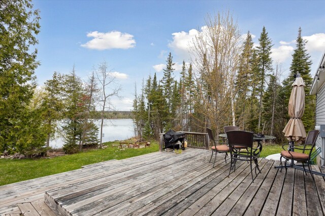 9168 Clewley Rd, Lachine, MI 49753 - wooden deck with a water view, outdoor dining space, and a lawn