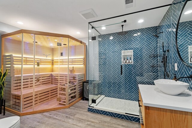 24346 Vargas Dr, Mattawan, MI 49071 - full bathroom featuring vanity, wood finished floors, a stall shower, recessed lighting, and tile walls