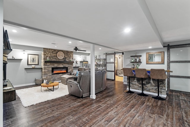 24346 Vargas Dr, Mattawan, MI 49071 - living area featuring a barn door, a stone fireplace, recessed lighting, dark wood-type flooring, and a dry bar