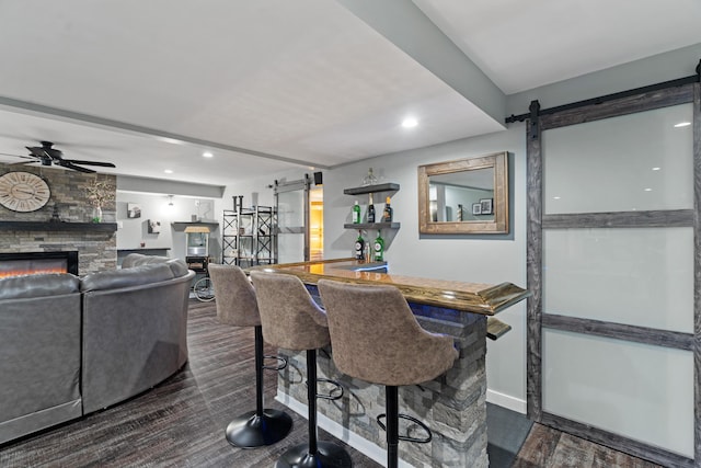 24346 Vargas Dr, Mattawan, MI 49071 - dining space featuring a barn door, dark wood finished floors, a fireplace, a ceiling fan, and recessed lighting