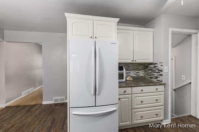 756 66th St SE, Grand Rapids, MI 49548 - kitchen featuring freestanding refrigerator, dark wood-style flooring, white cabinetry, tasteful backsplash, and baseboards