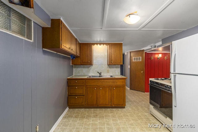 756 66th St SE, Grand Rapids, MI 49548 - kitchen featuring white appliances, a sink, brown cabinetry, light flooring, and tile counters