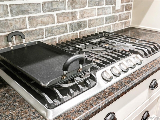 5076 Birch Ave, Lexington, MI 48450 - kitchen view of decorative backsplash, stainless steel gas stovetop, and dark countertops
