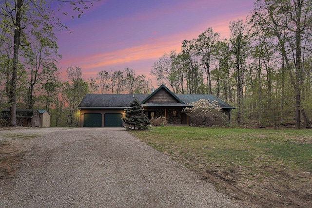 5301 Durga Rd, Williamsburg, MI 49690 - view of front of house with a garage, driveway, and a yard
