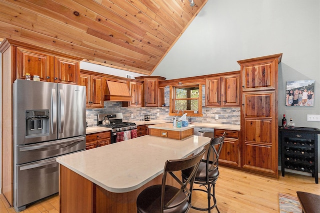 5301 Durga Rd, Williamsburg, MI 49690 - kitchen with stainless steel appliances, wine cooler, light countertops, brown cabinetry, and backsplash