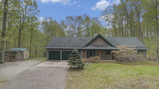 5301 Durga Rd, Williamsburg, MI 49690 - view of front of house with a garage, driveway, a chimney, a front lawn, and a shingled roof