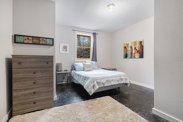 5301 Durga Rd, Williamsburg, MI 49690 - bedroom with concrete floors, baseboards, and a textured wall