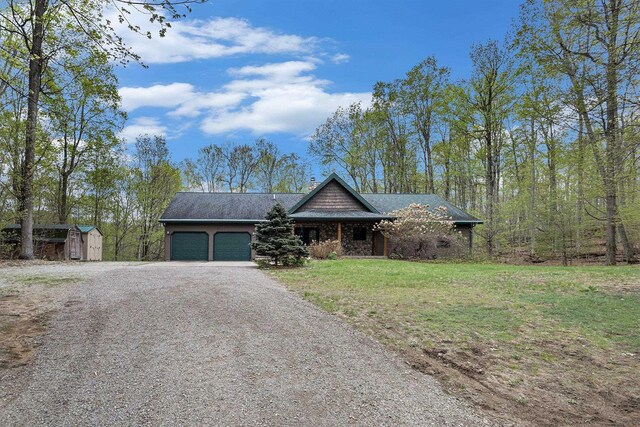 5301 Durga Rd, Williamsburg, MI 49690 - view of front of property featuring an attached garage, driveway, and a front lawn