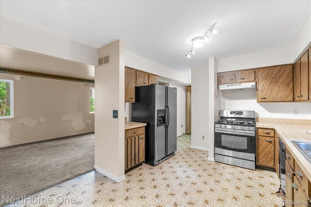 7469 Longworth Dr, Brighton, MI 48116 - kitchen featuring stainless steel appliances, light countertops, brown cabinets, and under cabinet range hood