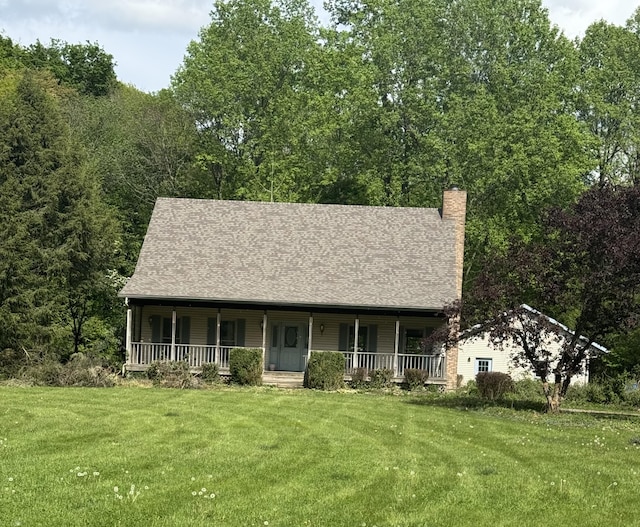 10109 Lauer Rd, Baroda, MI 49101 - view of front of home with covered porch, a front yard, a chimney, and roof with shingles