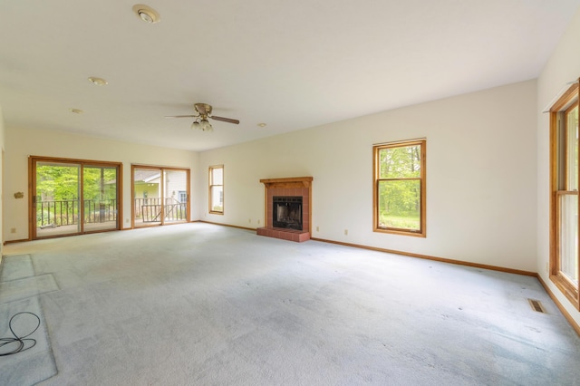 10109 Lauer Rd, Baroda, MI 49101 - unfurnished living room with light colored carpet, a tiled fireplace, ceiling fan, and baseboards