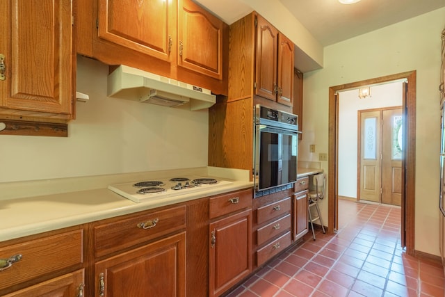 10109 Lauer Rd, Baroda, MI 49101 - kitchen featuring oven, under cabinet range hood, white electric cooktop, light countertops, and dark tile patterned floors