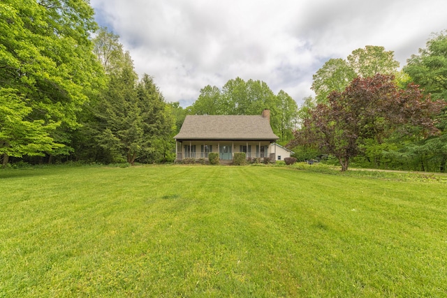 10109 Lauer Rd, Baroda, MI 49101 - view of front of home with a chimney, a front yard, and covered porch