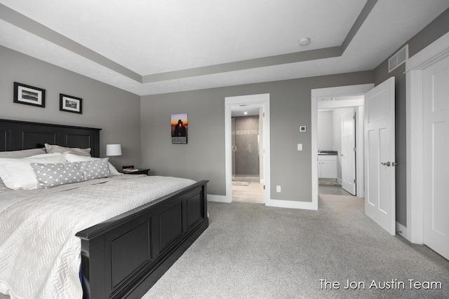 9012 N Wolven Ridge Ct, Rockford, MI 49341 - bedroom with baseboards, light colored carpet, ensuite bath, and a raised ceiling