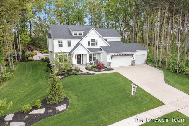9012 N Wolven Ridge Ct, Rockford, MI 49341 - view of front of house with concrete driveway, an attached garage, a front yard, a porch, and stone siding