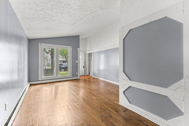 80 E Mahan Ave, Hazel Park, MI 48030 - spare room with a baseboard radiator, vaulted ceiling, wood finished floors, baseboard heating, and a textured ceiling