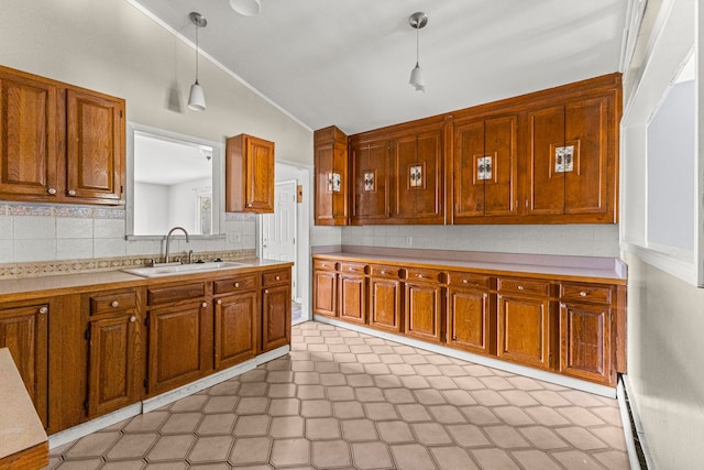 80 E Mahan Ave, Hazel Park, MI 48030 - kitchen featuring a sink, lofted ceiling, brown cabinetry, tasteful backsplash, and light countertops