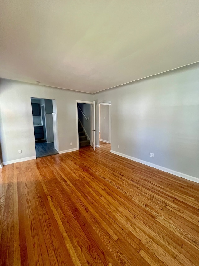 20244 Mccormick St, Detroit, MI 48224 - unfurnished room featuring wood finished floors, stairway, arched walkways, and baseboards