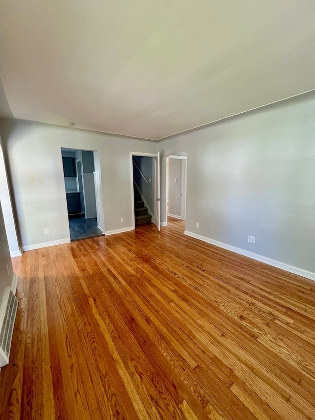 20244 Mccormick St, Detroit, MI 48224 - unfurnished room with arched walkways, wood finished floors, baseboards, and stairs