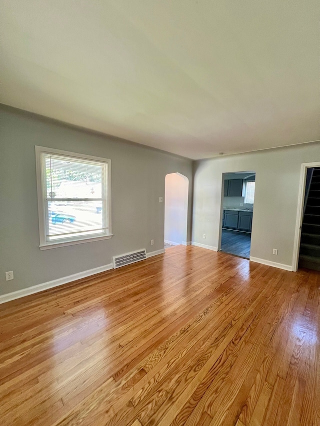 20244 Mccormick St, Detroit, MI 48224 - empty room with arched walkways, wood finished floors, plenty of natural light, and baseboards