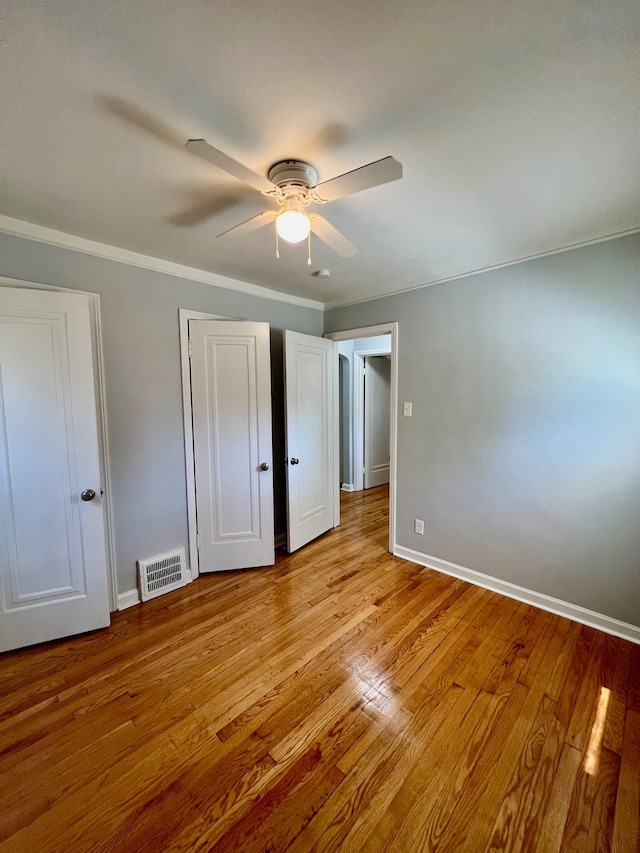 20244 Mccormick St, Detroit, MI 48224 - unfurnished bedroom with ornamental molding, wood finished floors, baseboards, and a ceiling fan